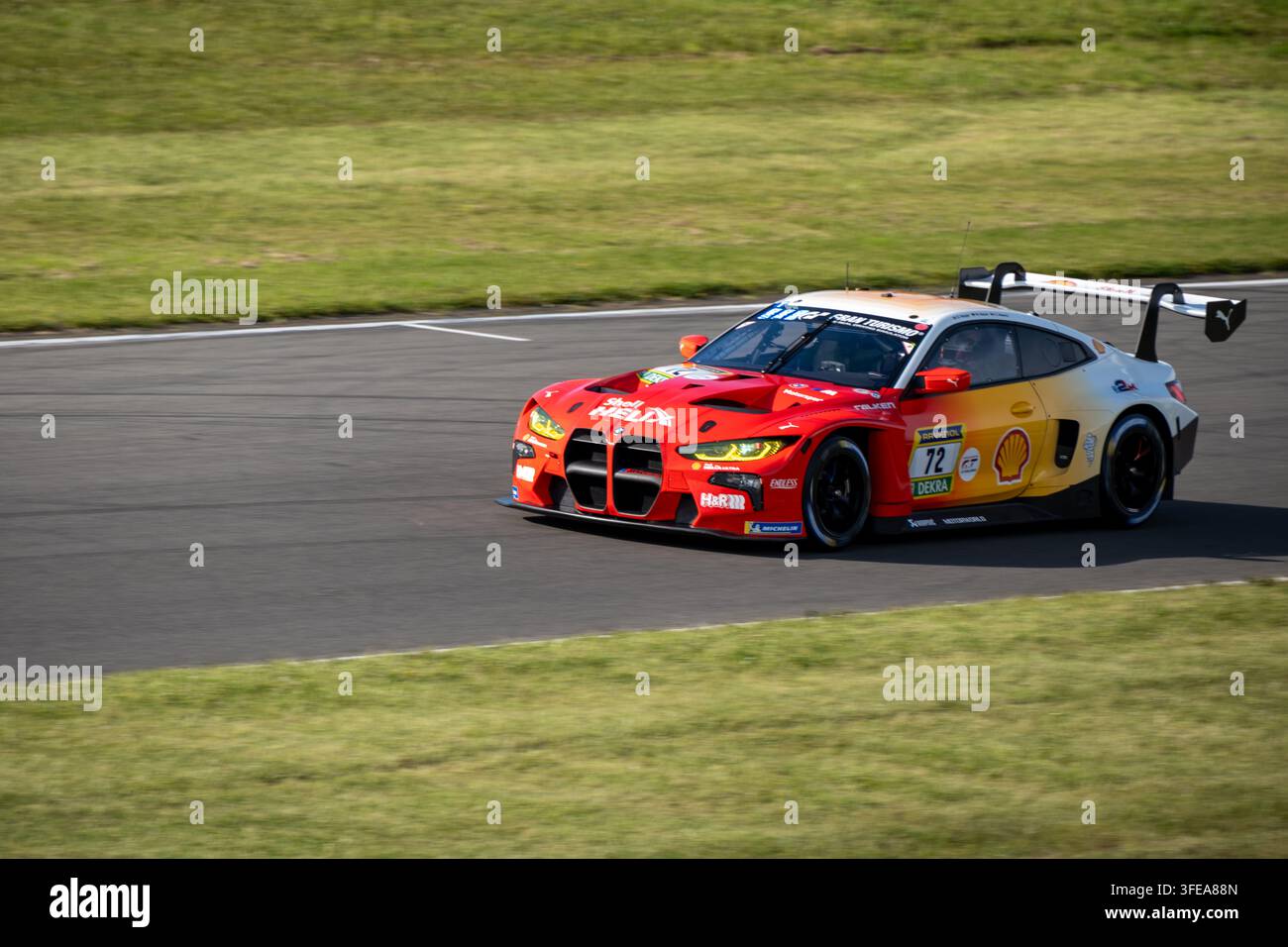Automobile da corsa BMW M4 GT3 con livrea Shell Helix in curva sul circuito, ideale per uso editoriale nel motorsport e nel settore automotive. Foto Stock