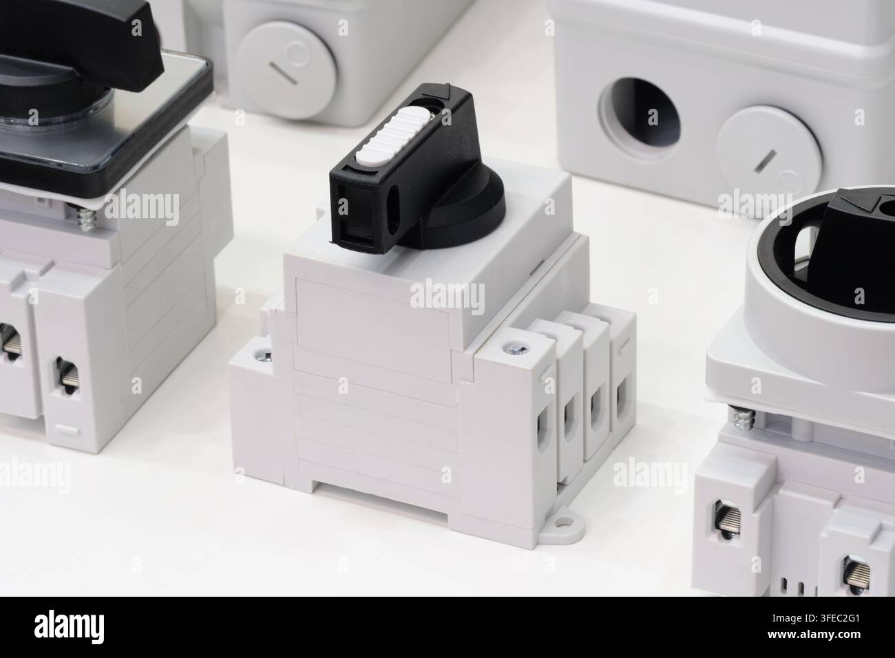 Relè elettrici in plastica bianca con manopole nere. Ogni unità ha viti di fissaggio e prese terminali. Sono disposti su uno sfondo neutro. Industriale Foto Stock