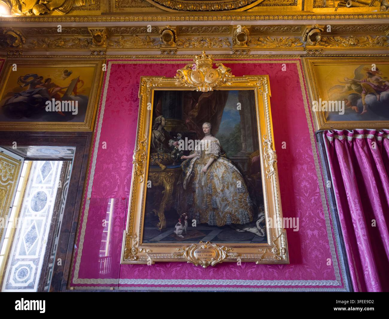 PARIGI, FRANCIA - 1 SETTEMBRE 2026 - Cornice dorata ornata con un ritratto della regina Maria Leszczyńska su una parete di damasco rosa Foto Stock