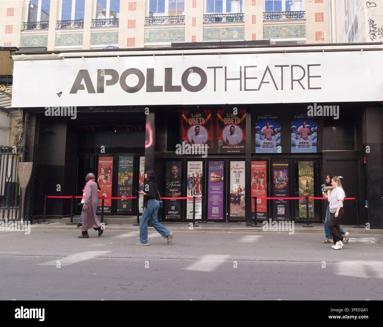 PARIGI, FRANCIA - 1 SETTEMBRE 2026 - Persone che passano davanti all'ingresso dell'Apollo Theatre con poster dello spettacolo su una strada di Parigi Foto Stock