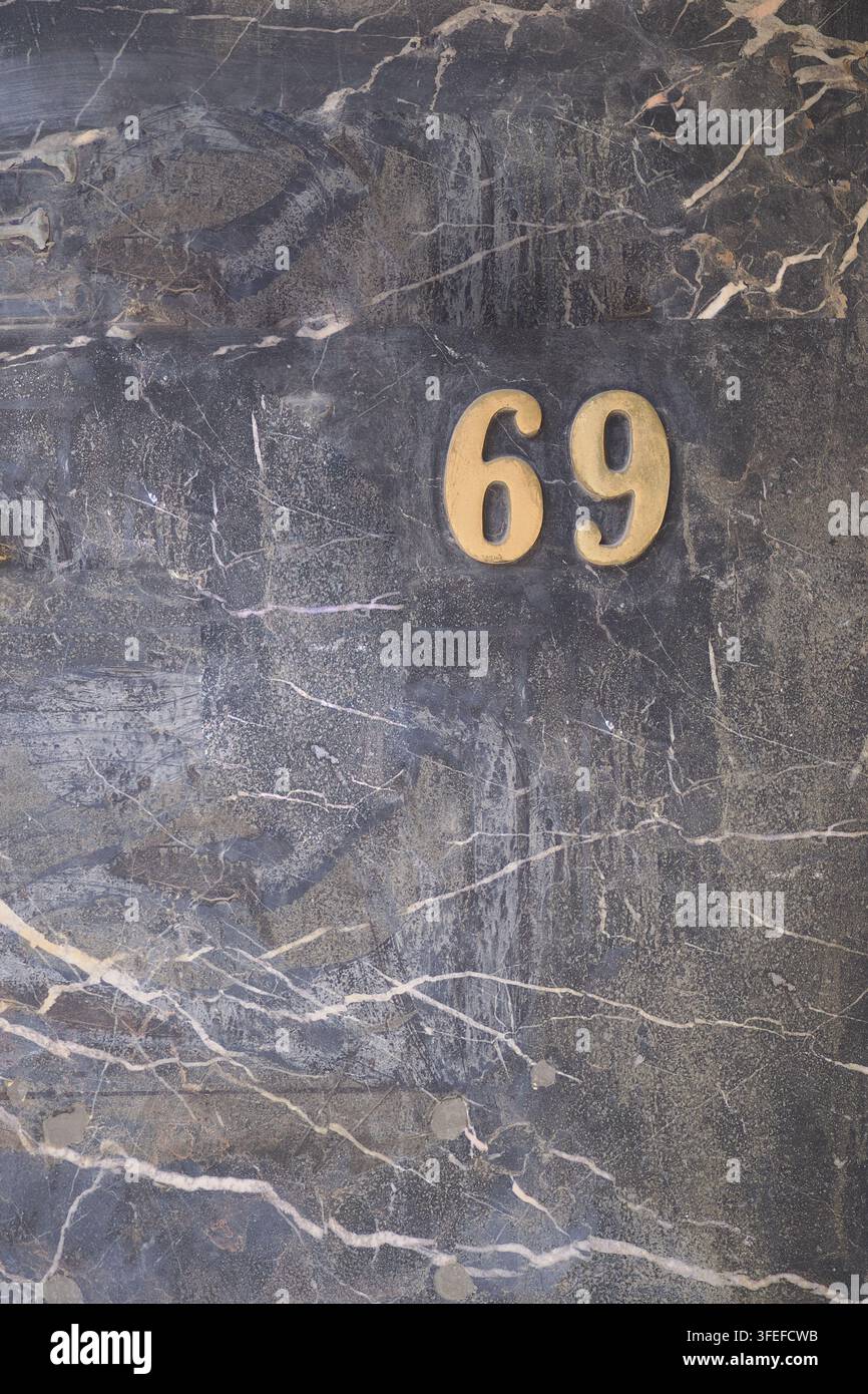 Numero 69 visualizzato su un muro di pietra Foto Stock