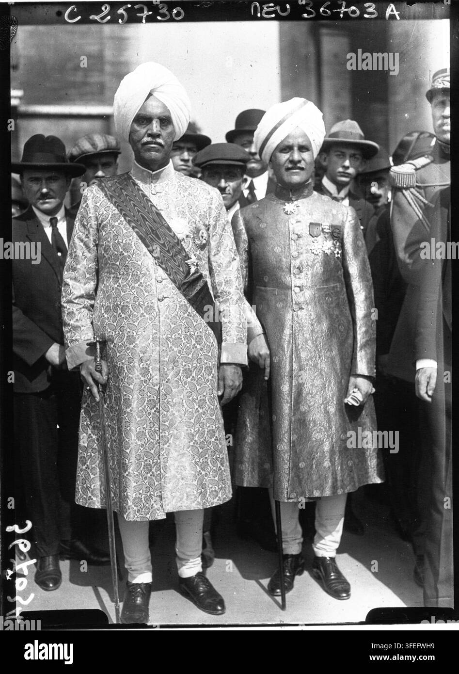 Il Maharaja di Kapurthala e il suo segretario, in abiti formali, in piedi davanti a un gruppo di uomini, dell'Agence Meurisse nel 1926. Foto Stock