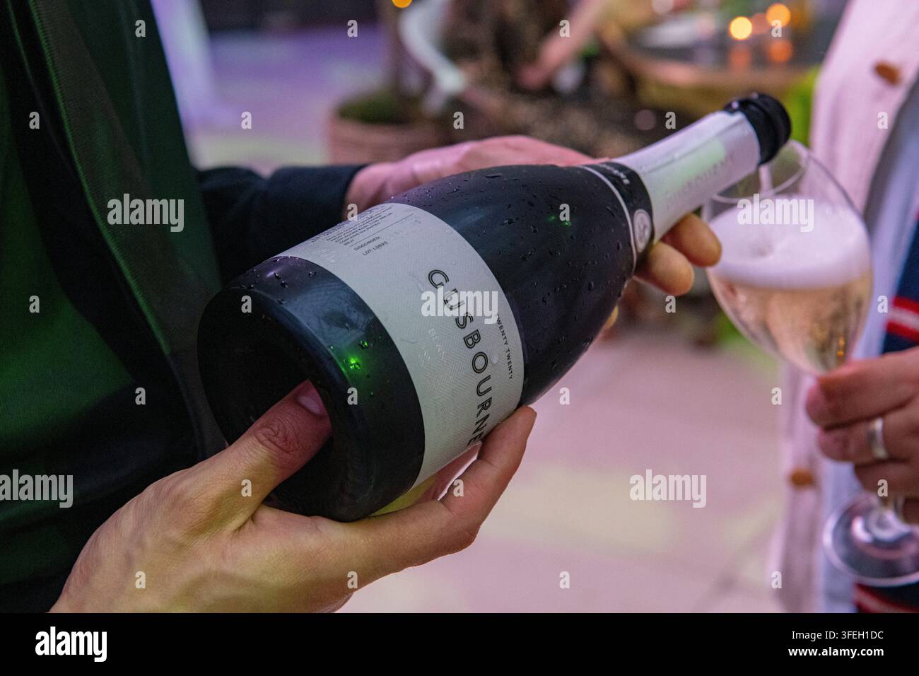 Un cameriere versa bicchieri di vino spumante inglese Gusbourne Foto Stock