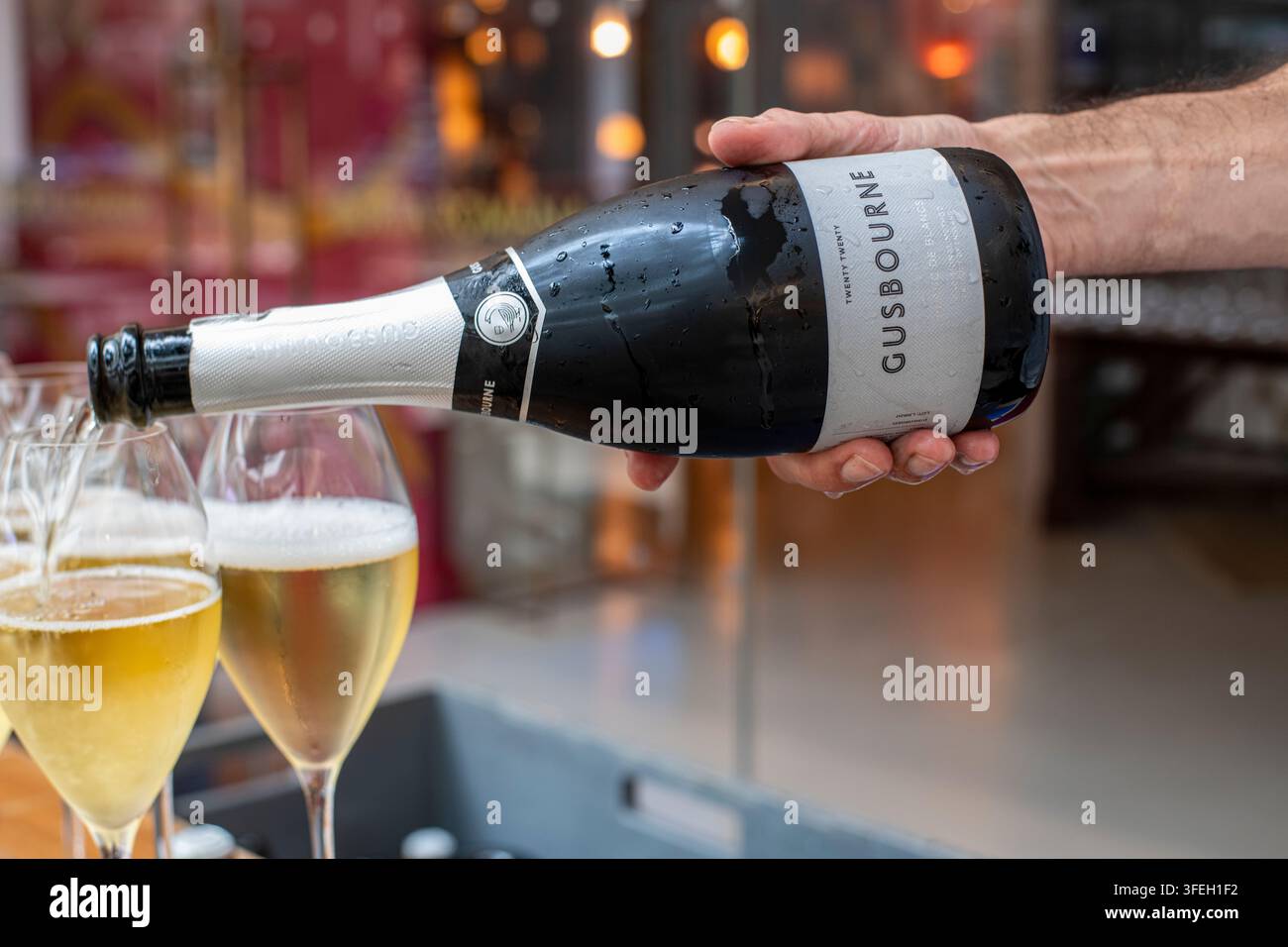 Un cameriere versa bicchieri di vino spumante inglese Gusbourne Foto Stock