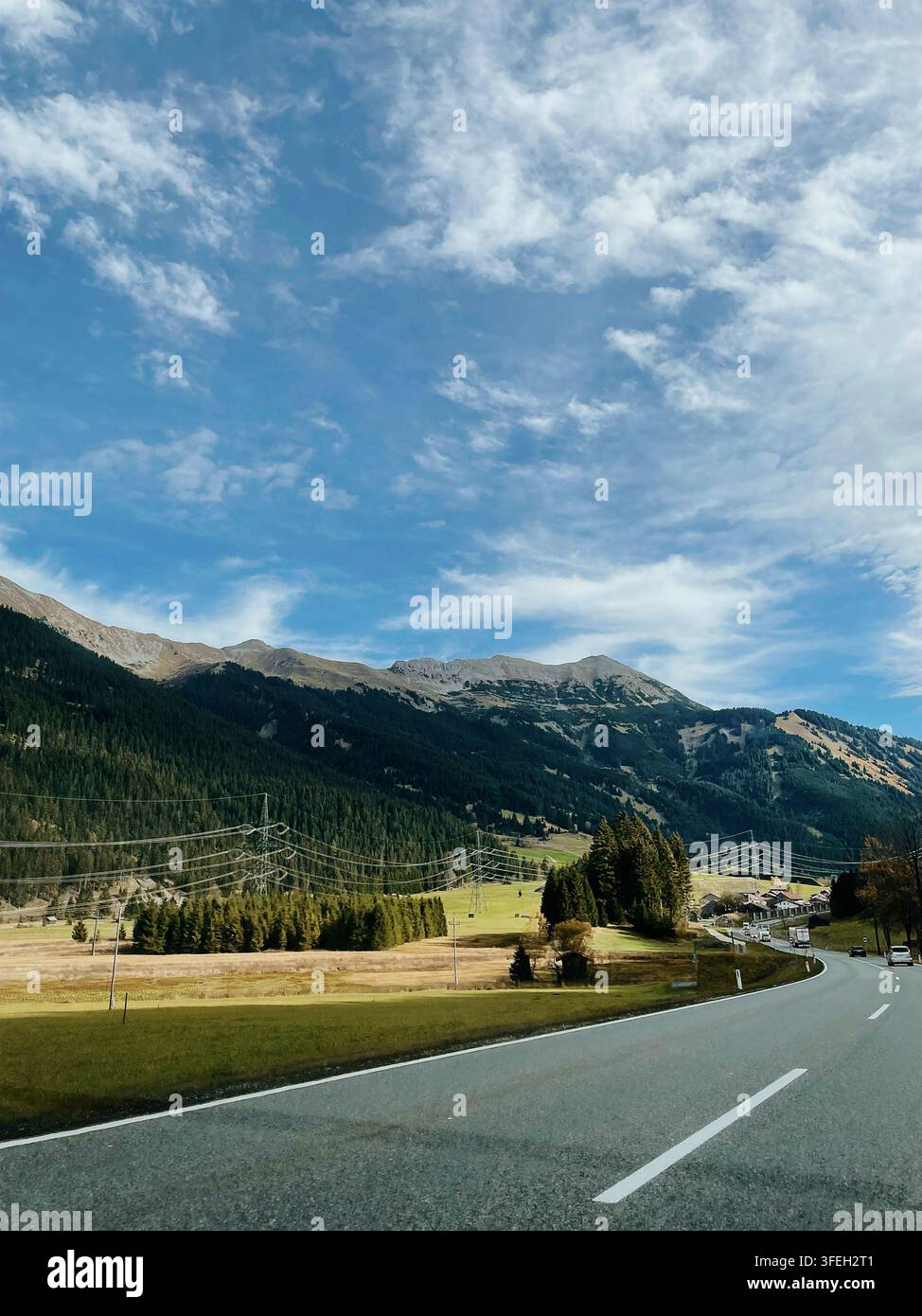 Strada panoramica attraverso le Alpi austriache, circondata da montagne, foreste sempreverdi e bellissimi paesaggi naturali, con auto che viaggiano lungo - Immagine stock catturata con smartphone