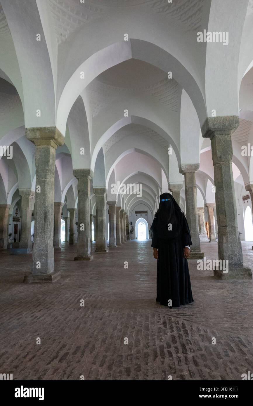 Donna in piedi tra le colonne all'interno della moschea Sixty Dome, divisione di Khulna, Bagerhat, Bangladesh Foto Stock