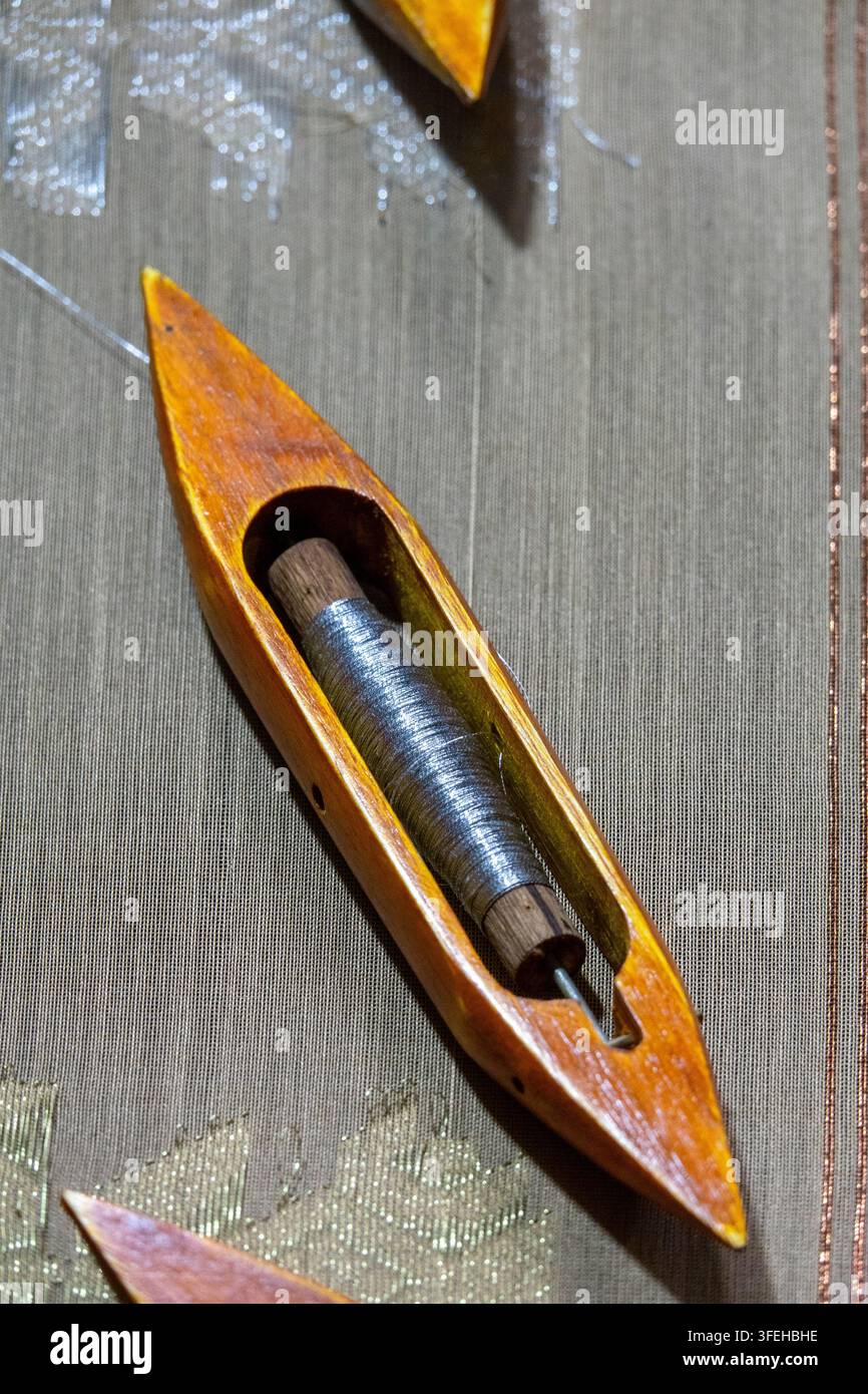 Navetta di legno carica di filo metallico usato nella tessitura del sari, Divisione di Dhaka, Delduar, Bangladesh Foto Stock
