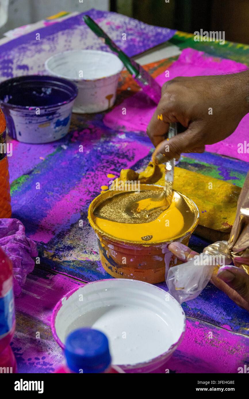 Prima piano di una mano che mescola una pasta colorante dorata per la stampa a blocchi manuali, Divisione di Dhaka, Dhaka, Bangladesh Foto Stock