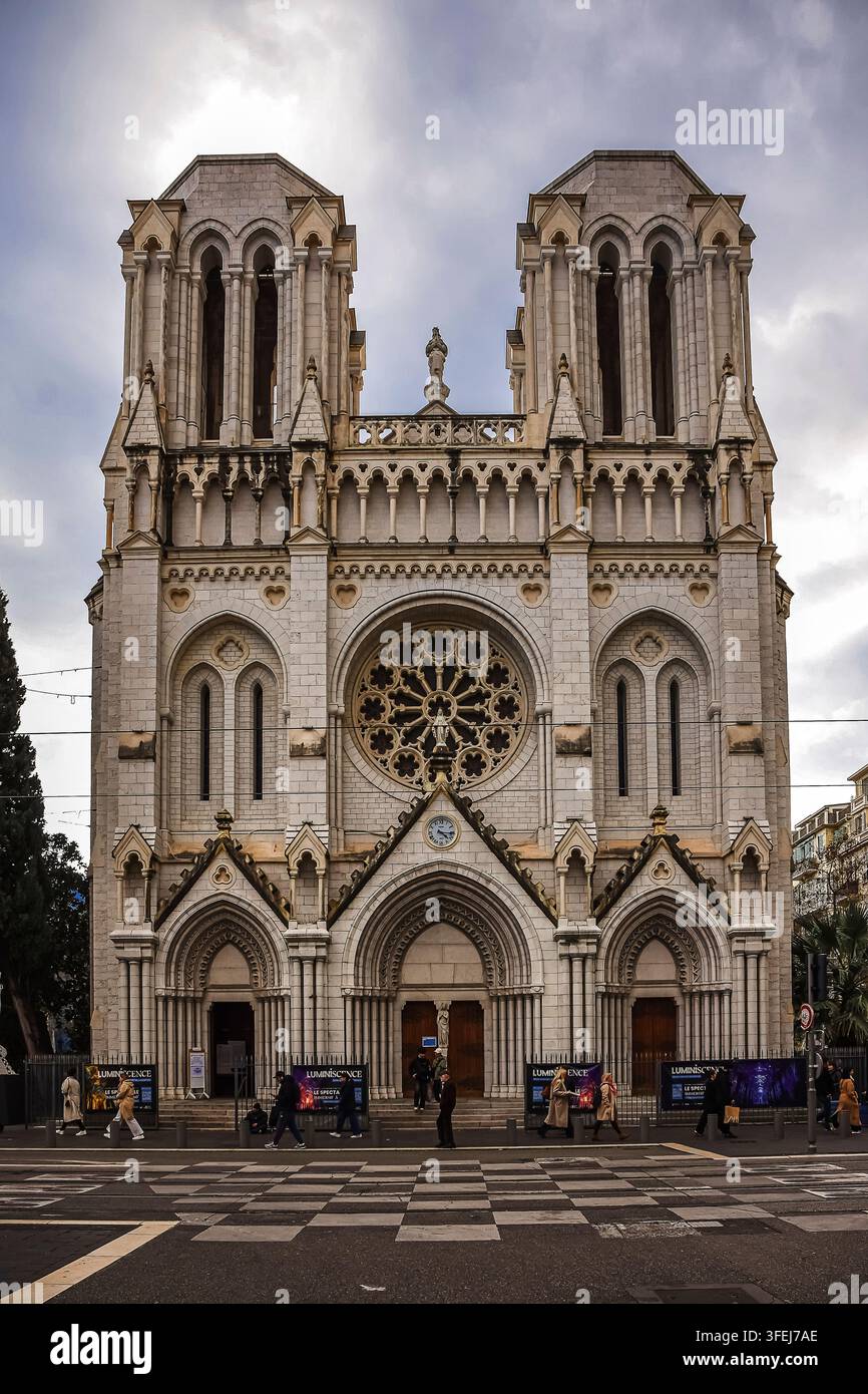 La facciata della Basilica di Notre-Dame a Nizza, con turisti che attraversano la strada. Foto Stock