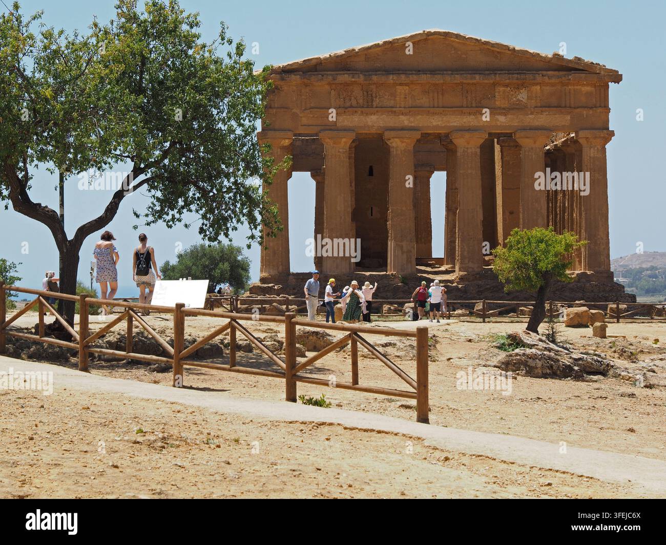 Facciata anteriore del tempio della Concordia ad Agrigento, con alcuni visitatori. Sicilia, Italia. Costruito 440-430 a.C. Foto Stock