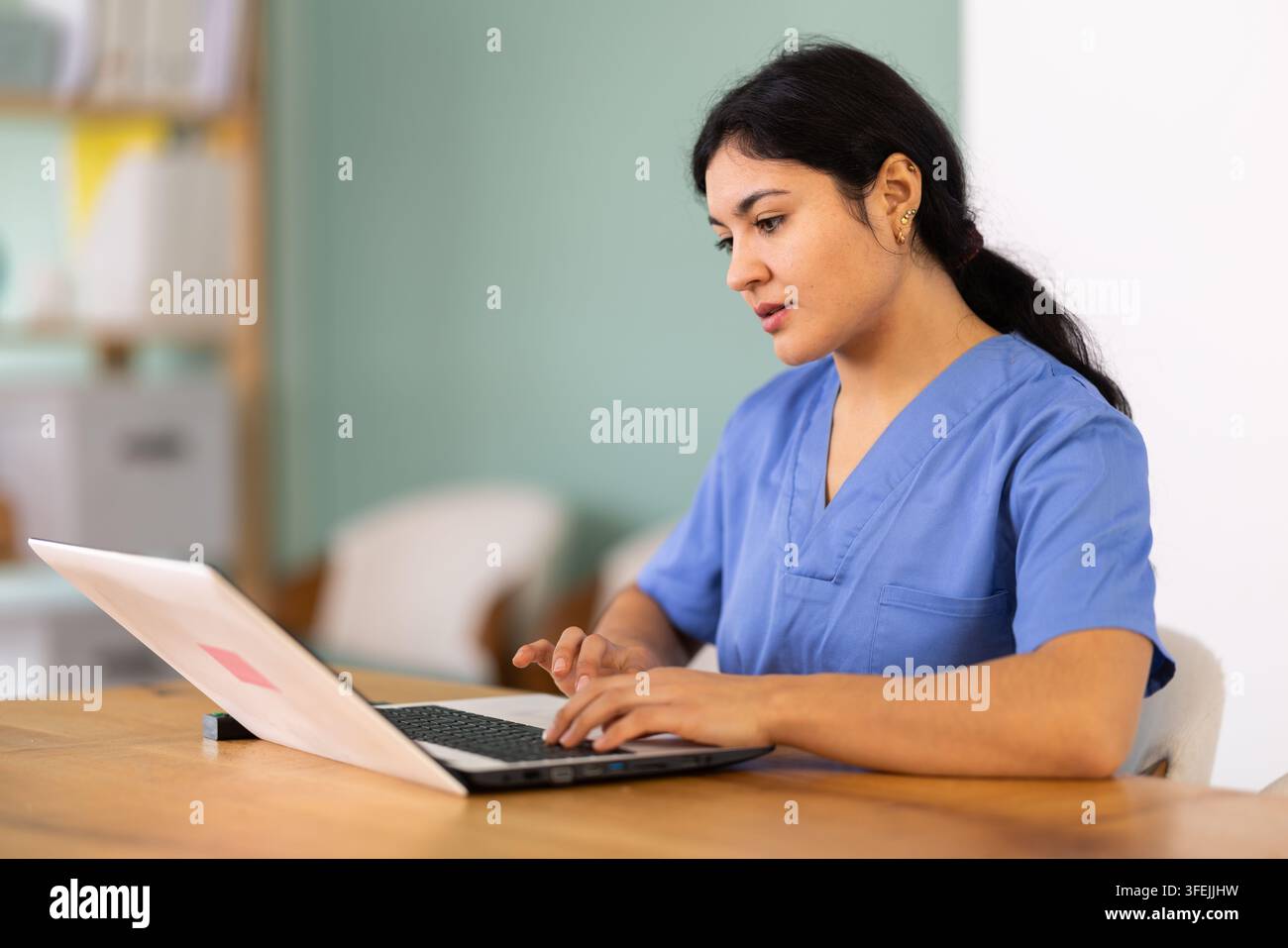 Medica donna lavora su un laptop nella stanza. Consulente di telemedicina o responsabile clinica, consulente medica. Foto Stock