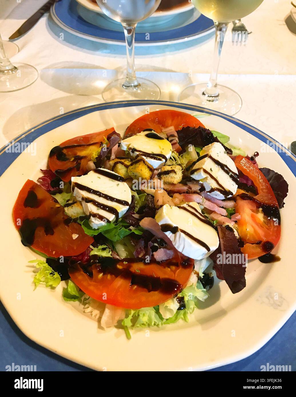 Insalata mista a base di pomodoro, lattuga, formaggio fresco, pancetta e pane. Foto Stock