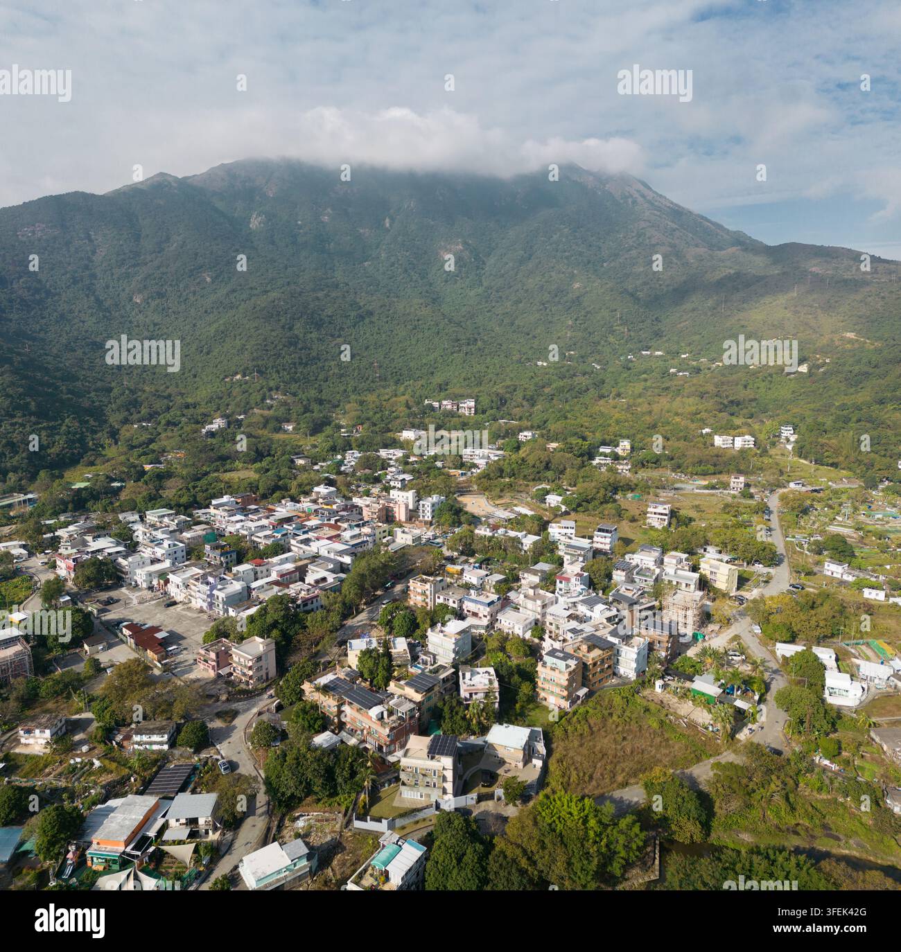 I residenti vivono a Mui Wo, una città rurale su Lantau Island, Hong Kong, incastonata sotto uno scenario montuoso lussureggiante per una vita isolana tranquilla. Foto Stock
