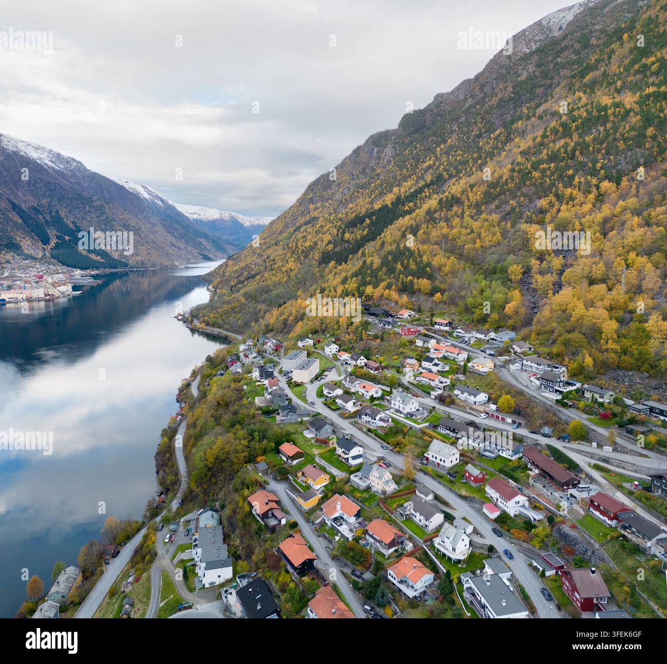 I residenti vivono a Odda, una città panoramica lungo il Sørfjorden a Hardanger, in Norvegia, incastonata sotto montagne autunnali per abbracciare la vita del fiordo. Foto Stock