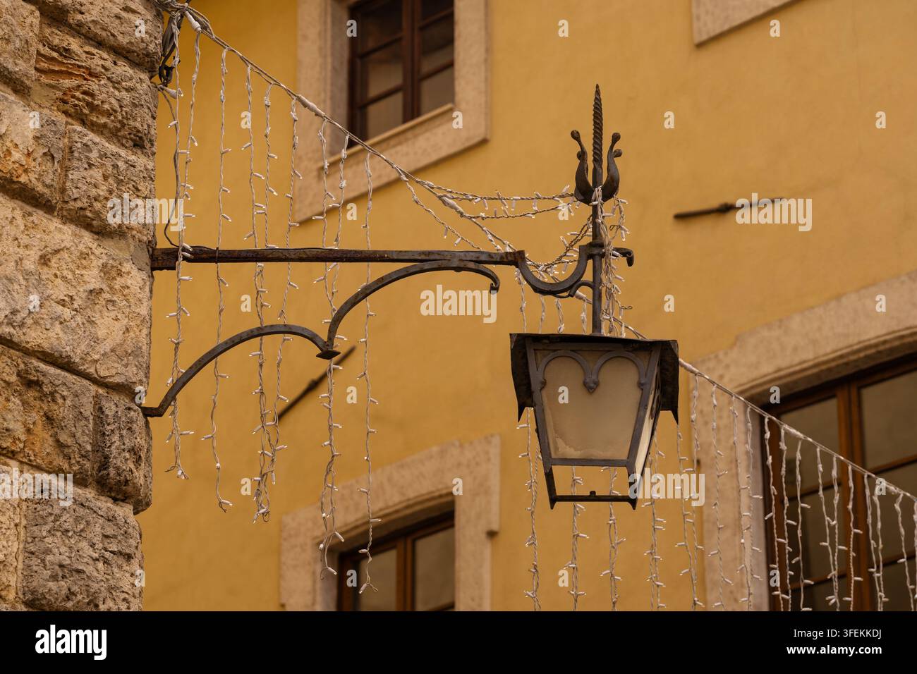 Lampione vintage con luci a filo contro un muro giallo Foto Stock