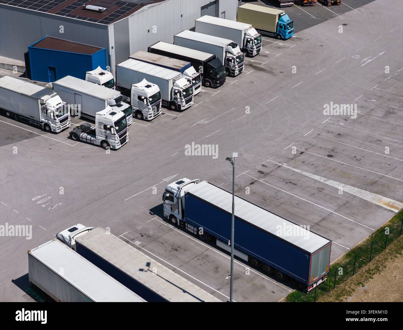 Vista aerea di un centro logistico mostra numerosi camion parcheggiati in un terminal di carico. Foto Stock