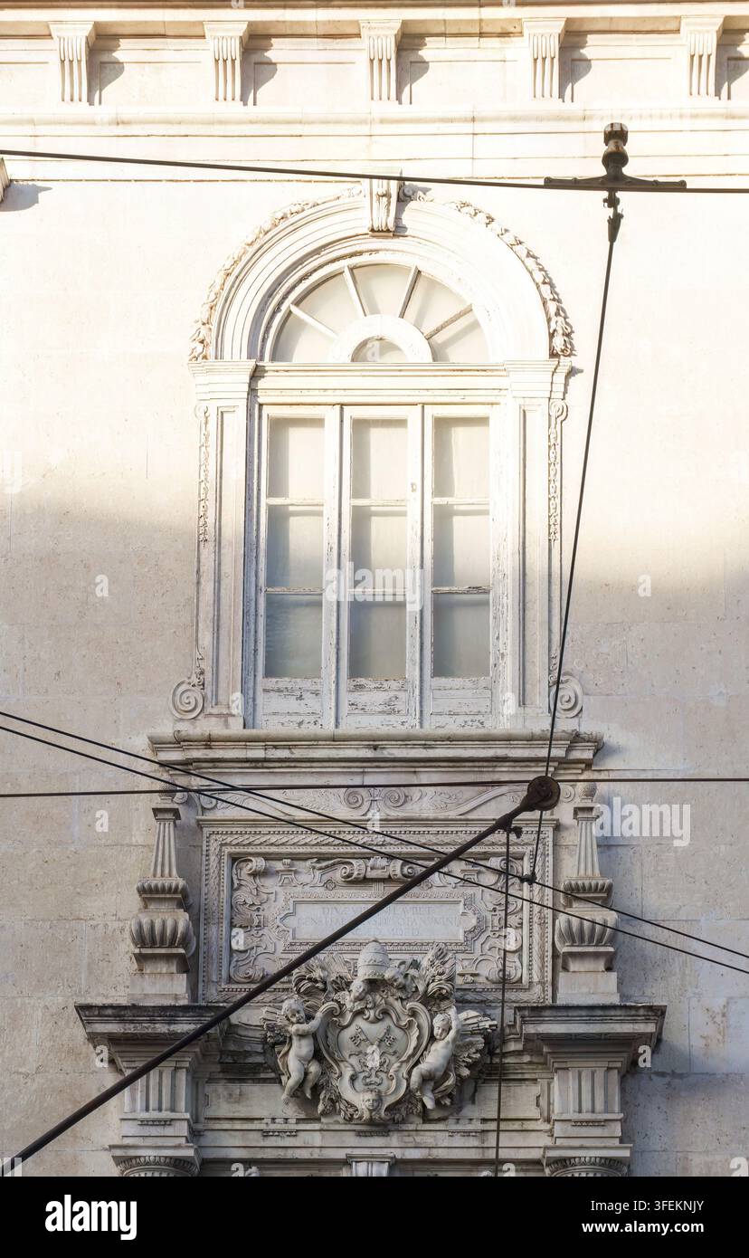 Tram davanti alla chiesa cattolica di Lisbona con stucchi e bassorilievi con angeli sulla facciata. Veduta della città Foto Stock
