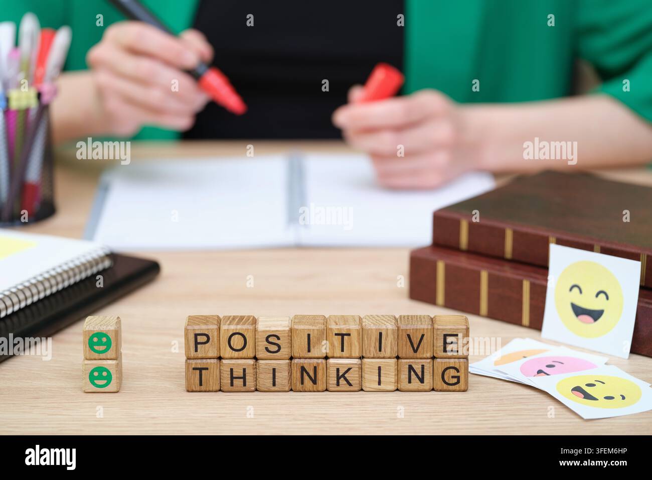 Spazio di lavoro creativo che promuove il pensiero positivo con espressioni allegre e materiali di studio organizzati Foto Stock