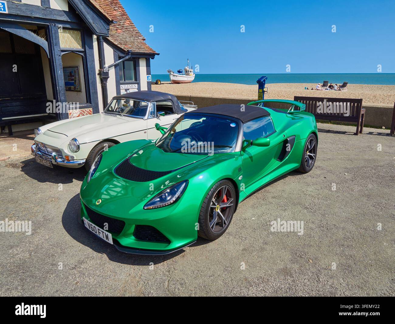 Cabriolet verde della Lotus Sport parcheggiato a Pebble Beach con un'auto MG classica e vista sul mare Foto Stock
