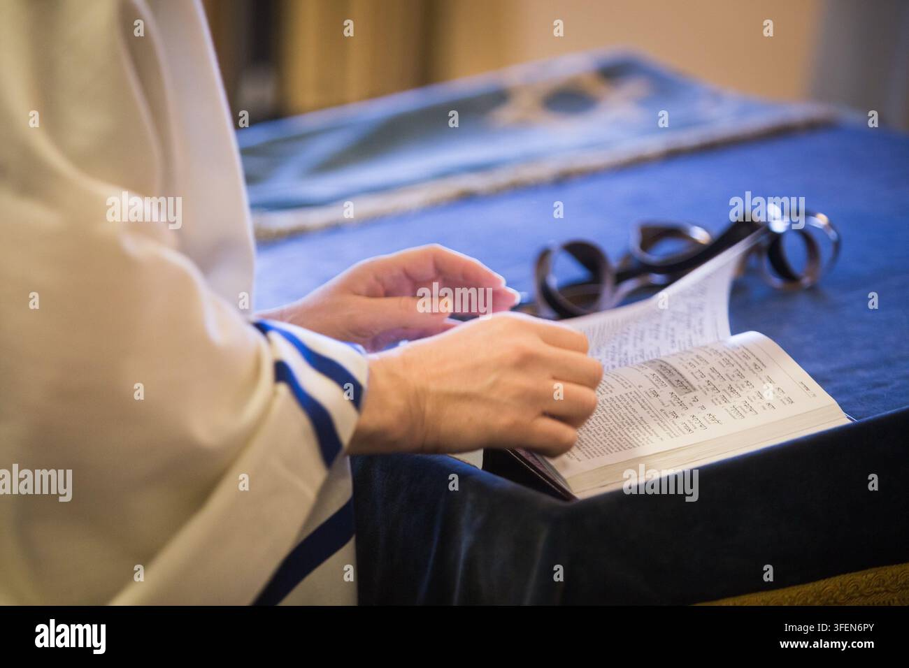 Un devoto ebreo che indossa un tallit legge la Torah per la preghiera e lo studio spirituale al Muro del Pianto a Gerusalemme. Foto Stock
