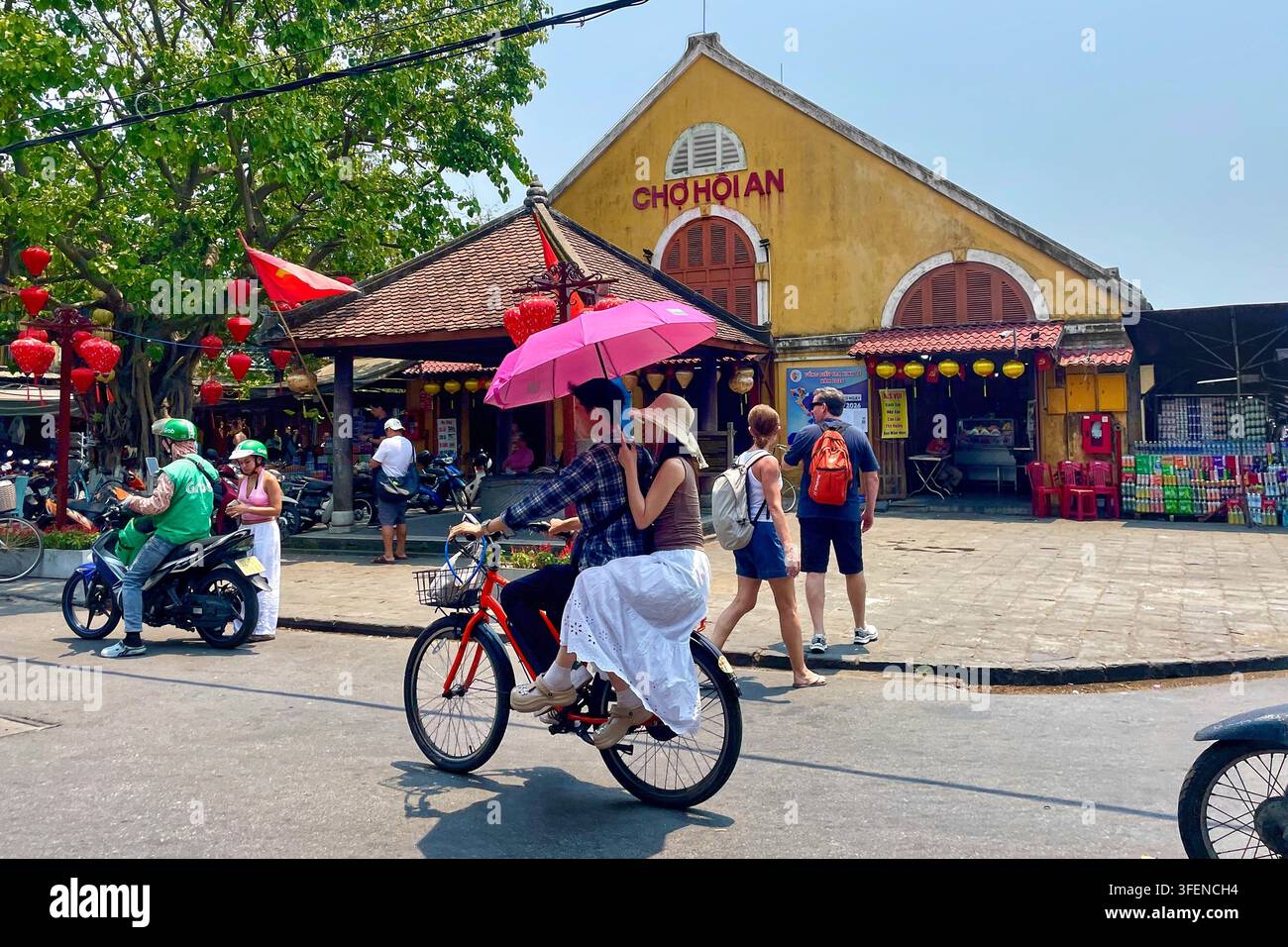 Turisti e locali che camminano davanti al mercato di Hoi An sotto la luce del giorno, Hoi An Old Town, Vietnam, 1 aprile 2026 Foto Stock