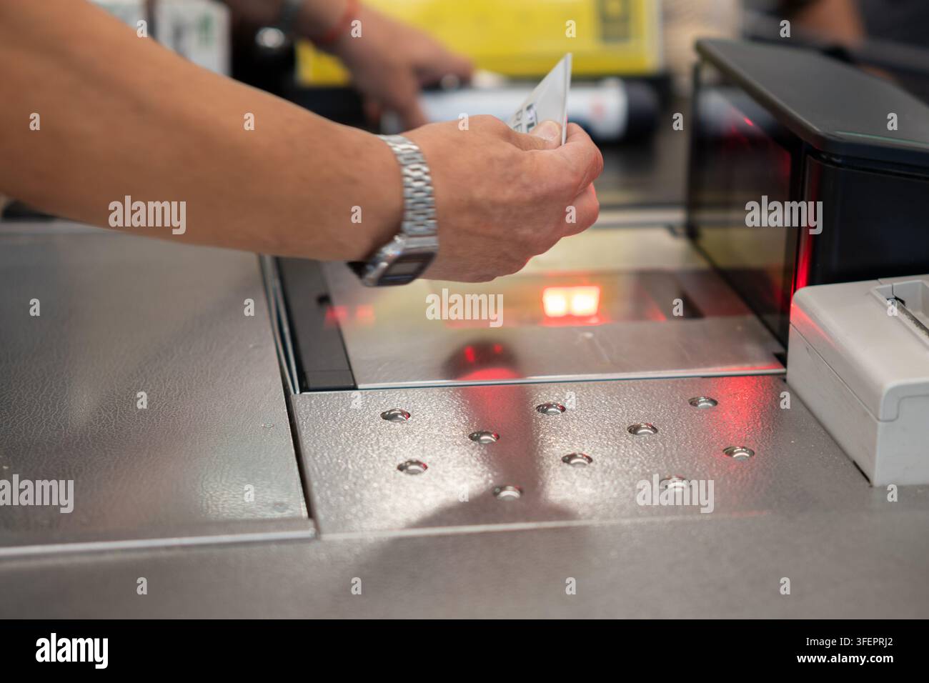 La mano di una persona che scansiona il codice a barre del prodotto alla cassa di un supermercato moderno Foto Stock
