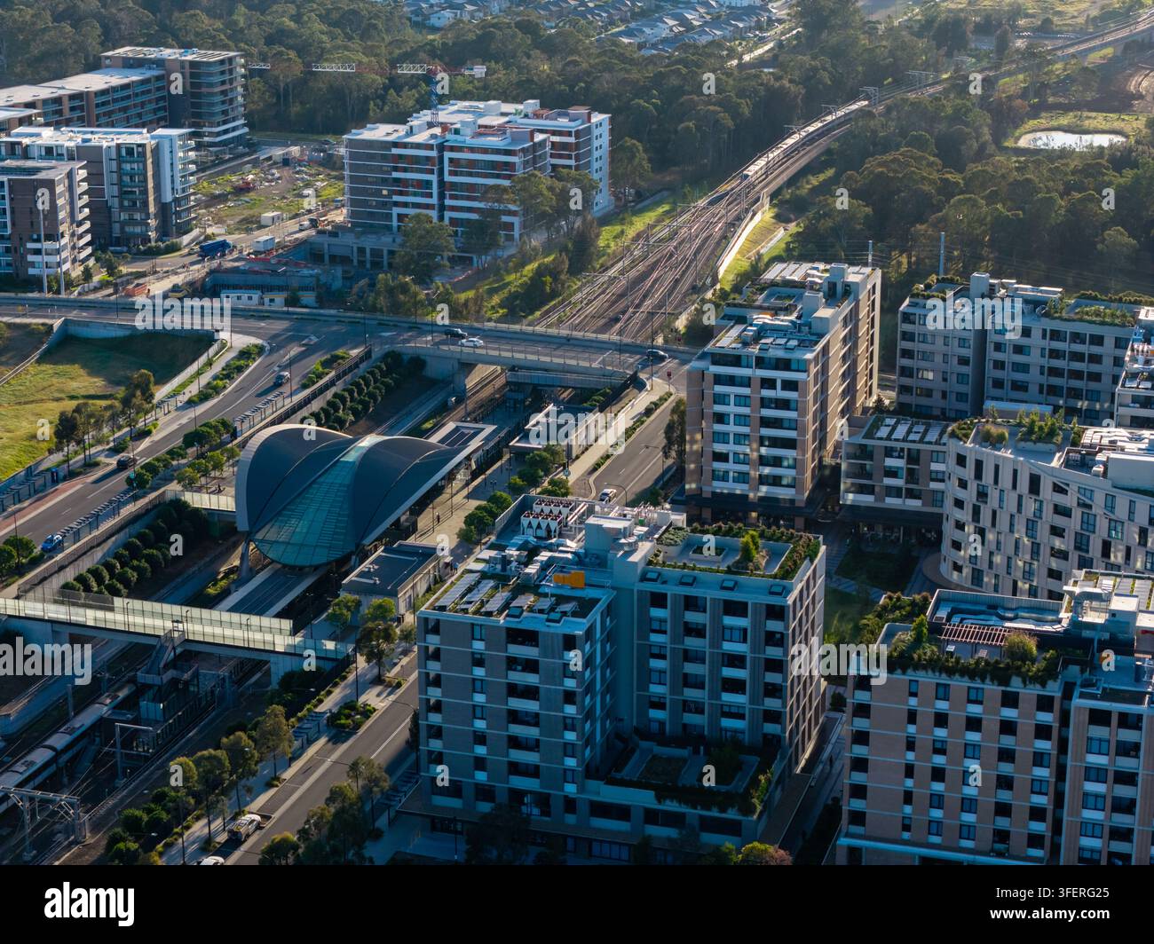 Vista aerea del moderno quartiere della stazione della metropolitana di Tallawong con edifici residenziali contemporanei, un corridoio ferroviario e sviluppo orientato ai trasporti Foto Stock