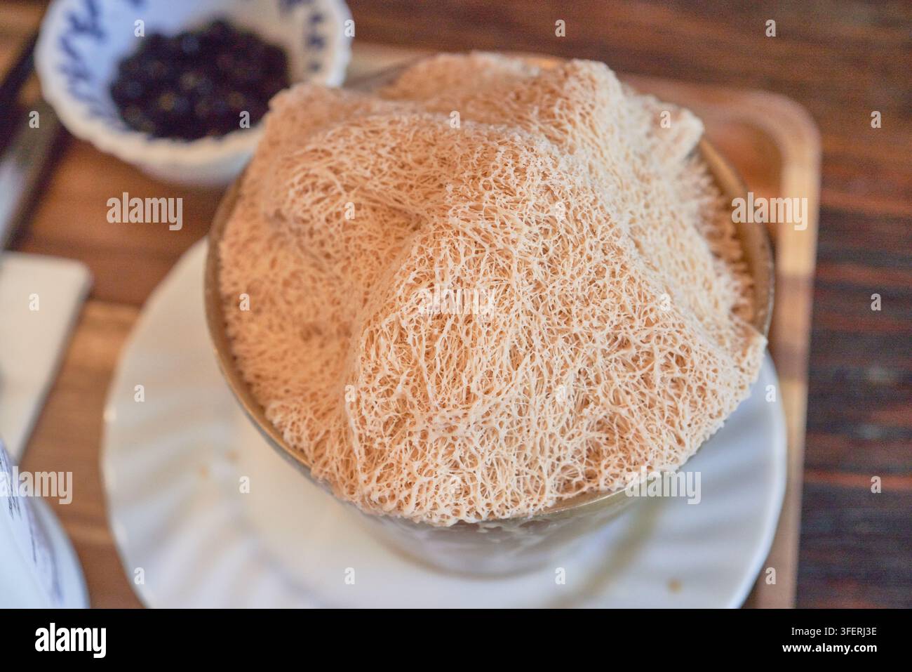 Una vista ravvicinata di un delicato tè al latte ghiacciato raschiato con una texture a filo fine, servito con perle di tapioca Foto Stock