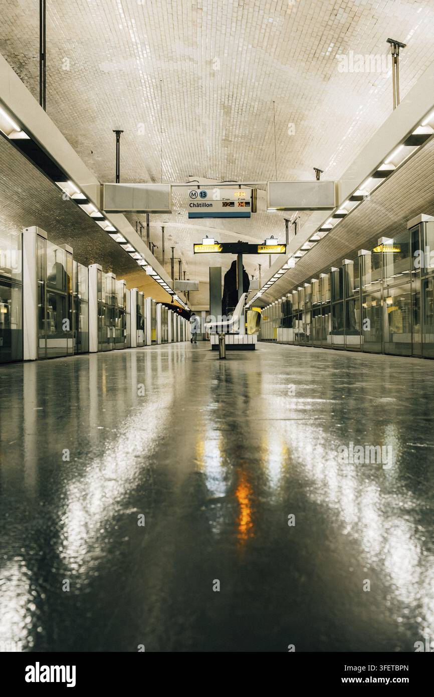 Stazione della metropolitana sotterranea in un design moderno e urbano con un'estesa costruzione del soffitto, piastrelle murali luminose e una superficie del pavimento lucida e pulita con un cen Foto Stock