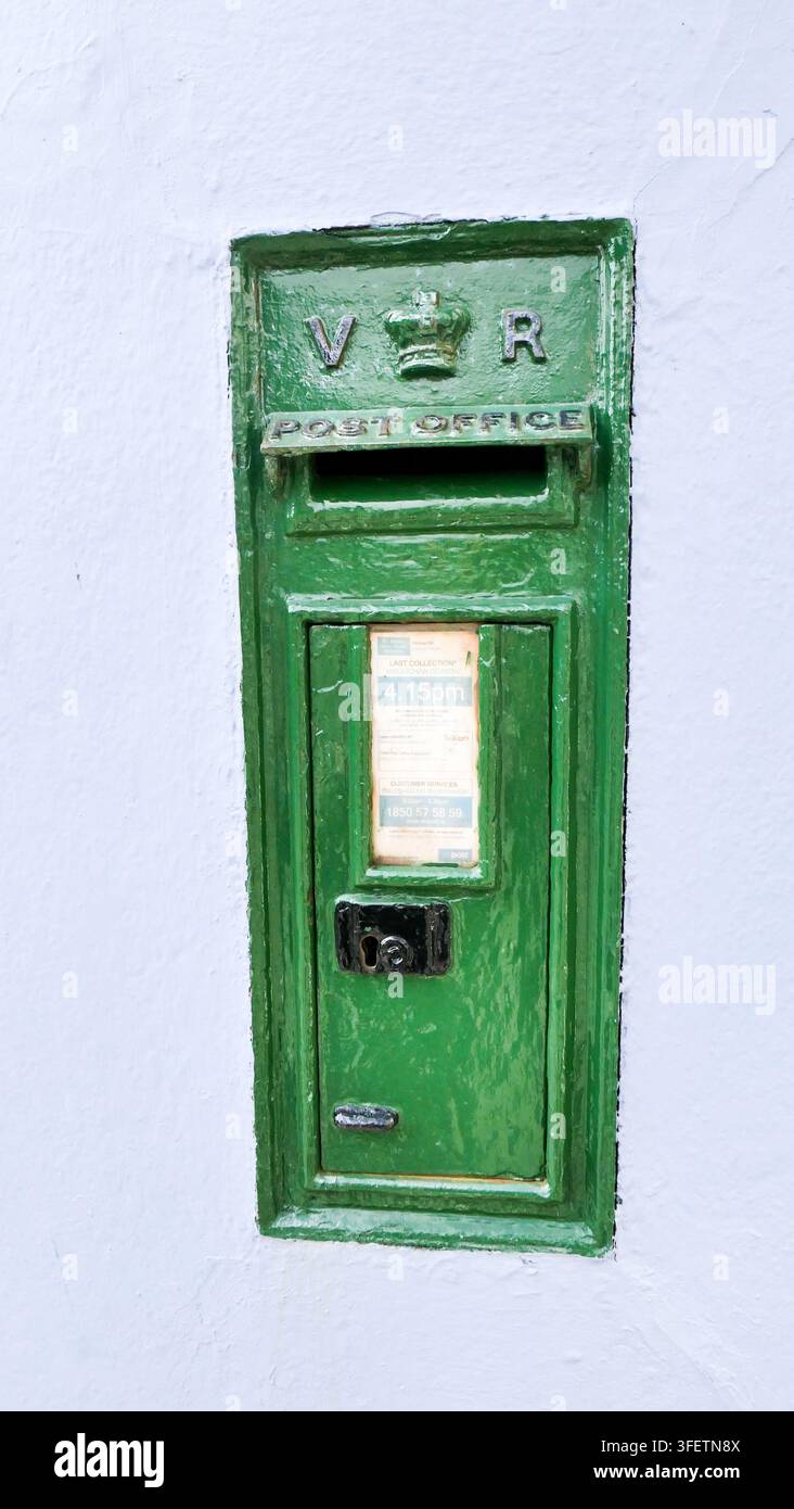 Cassetta delle poste verde, incassata in un muro di pietra bianca. Irlanda. Foto Stock