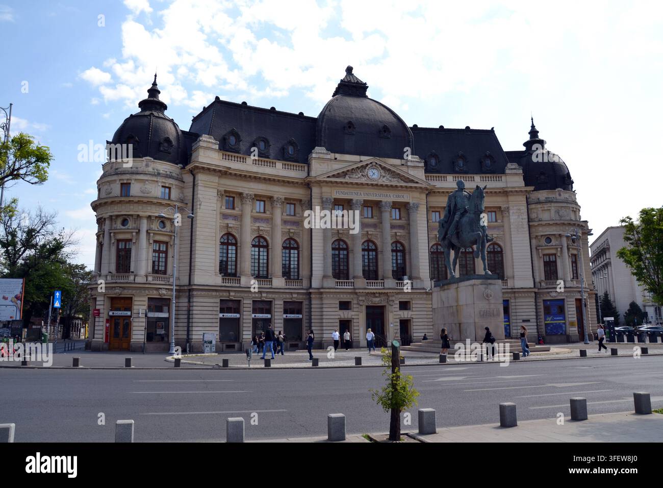 Biblioteca centrale universitaria e statua equestre di re Carlo I sotto un cielo blu, Piazza della Rivoluzione, Bucarest, Romania. Foto Stock