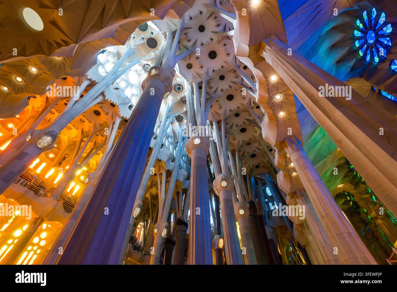 Barcellona, Spagna – 15 aprile 2026: I vetri colorati creano effetti mozzafiato di luce e ombra colorate all'interno dell'iconica chiesa della Sagrada Familia. Foto Stock