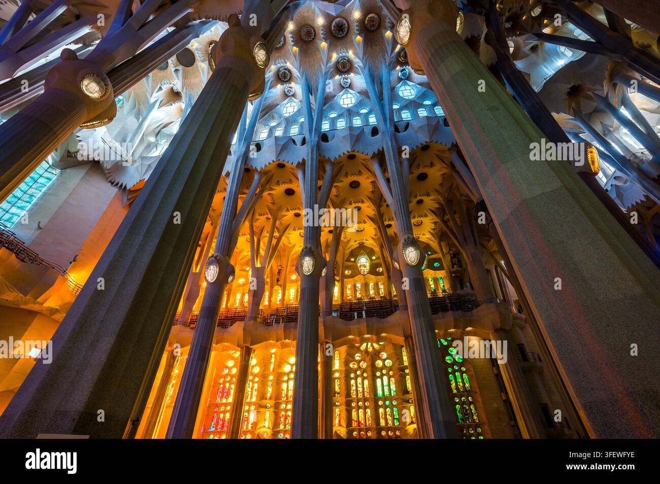 Barcellona, Spagna – 15 aprile 2026: I vetri colorati creano effetti mozzafiato di luce e ombra colorate all'interno dell'iconica chiesa della Sagrada Familia. Foto Stock