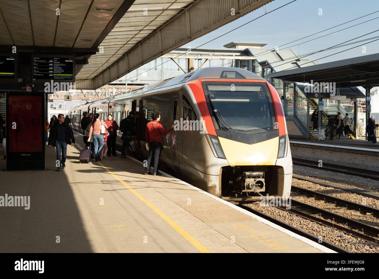 I passeggeri salgono su un treno Greater Anglia al binario 4 della stazione ferroviaria di Cambridge per viaggiare. Foto Stock