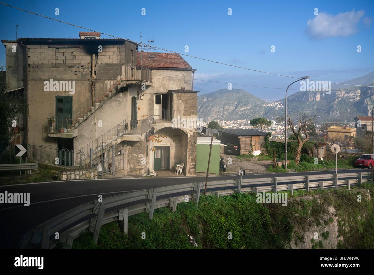 I residenti vivono in una casa rustica sul ciglio della strada nella penisola sorrentina dell'Italia, godendosi le viste sulle montagne lungo la panoramica costiera amalfitana. Foto Stock