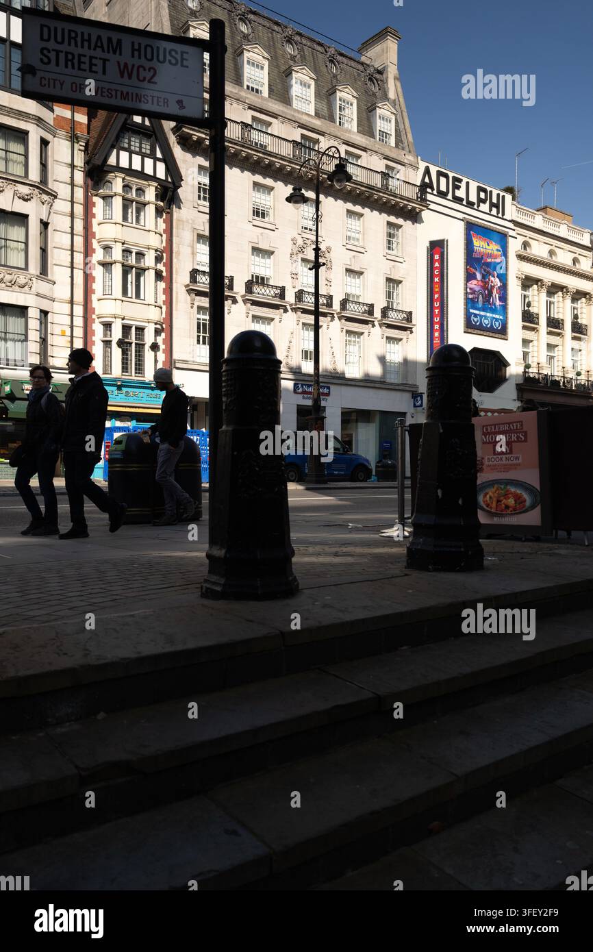 Le persone passeggiano lungo lo Strand oltre l'Adelphi Theatre a Westminster, Londra, per esplorare il West End. Foto Stock