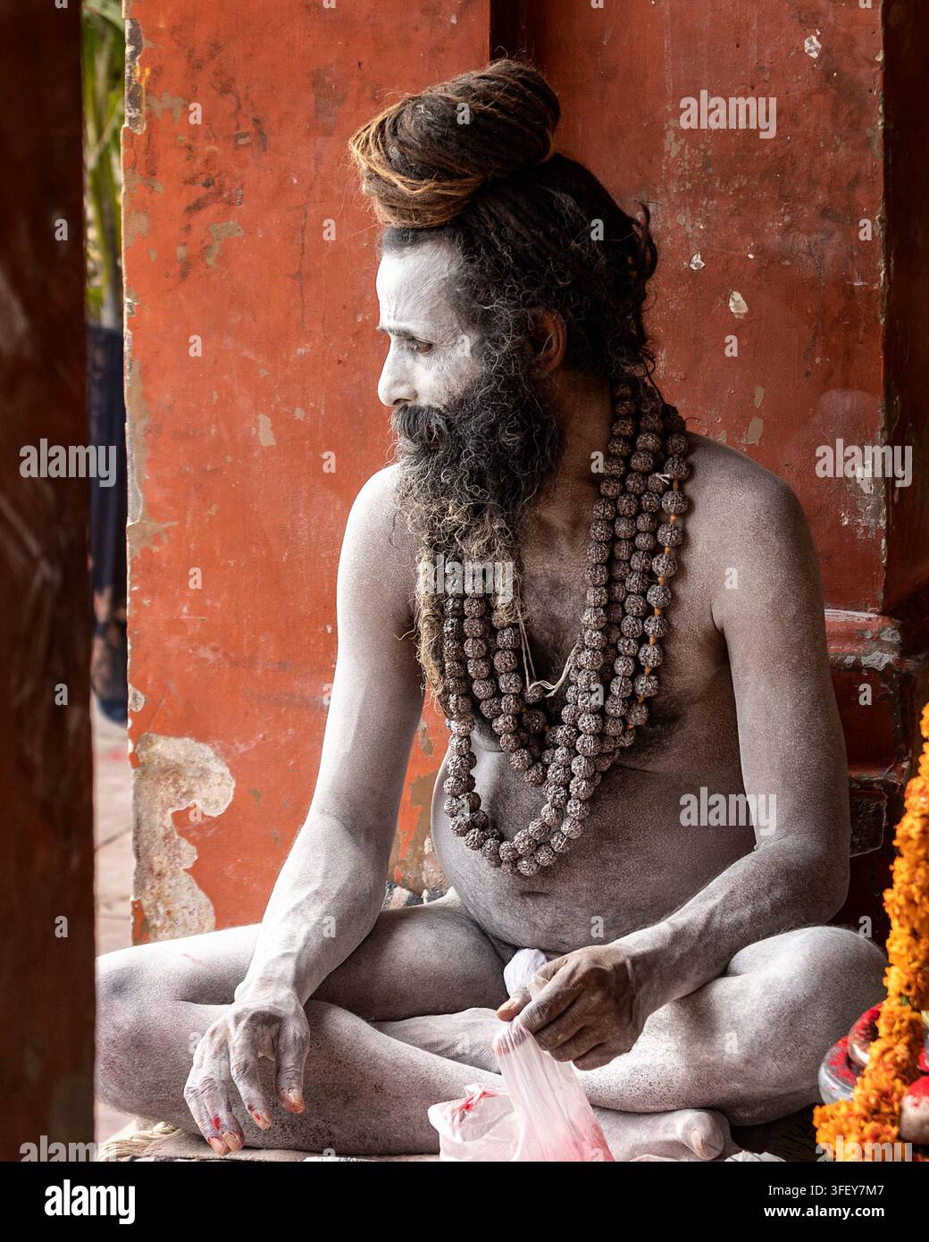 Uomo santo indù seduto con le sue preghiere durante le celebrazioni di Holi a Varanasi, Uttar Pradesh, India, l'8 marzo 2023. Foto Stock