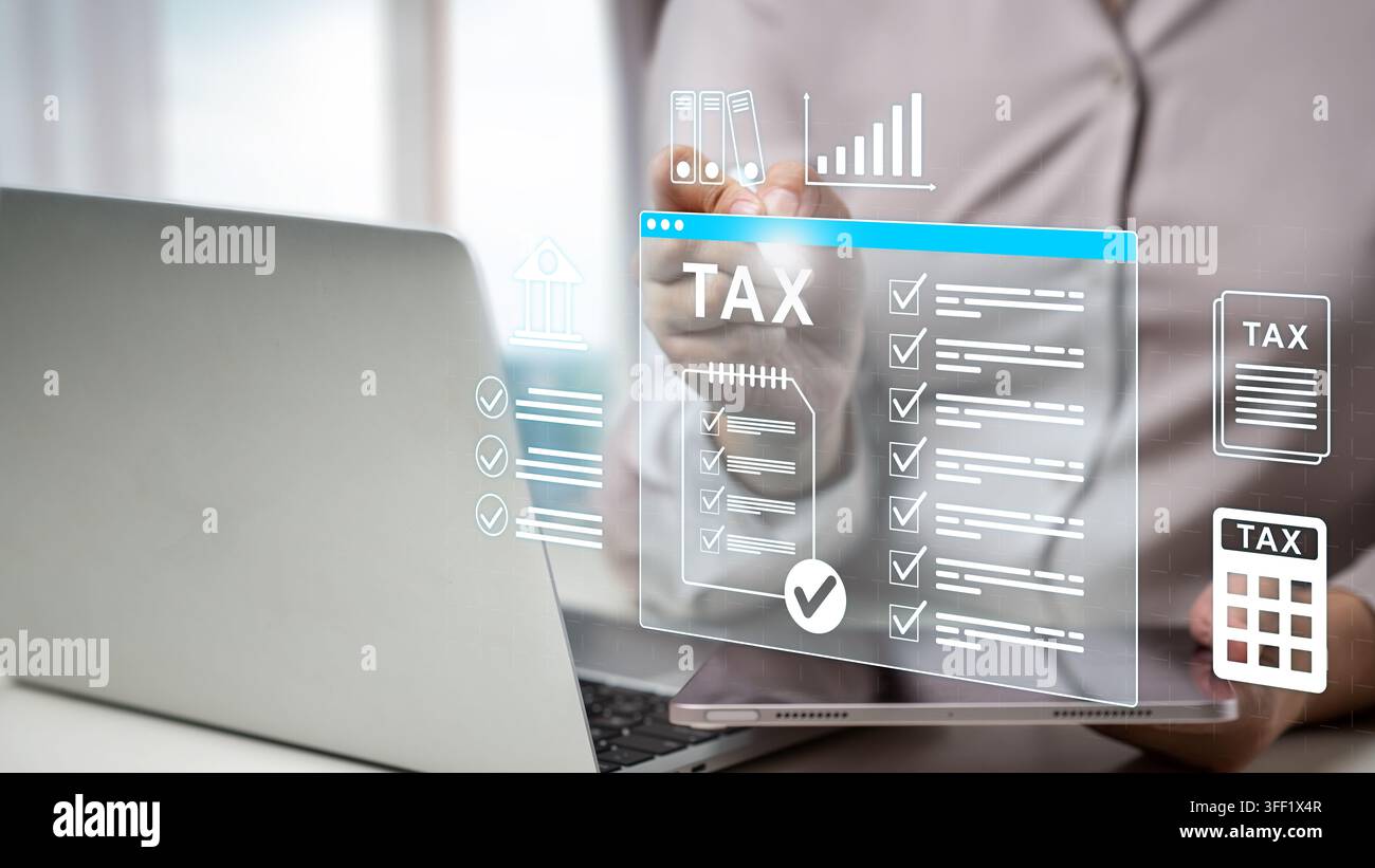 Una donna d'affari che compila le tasse online utilizzando un laptop e un tablet con una lista di controllo virtuale e icone finanziarie. Concetto di imposta immobiliare e catastale Foto Stock
