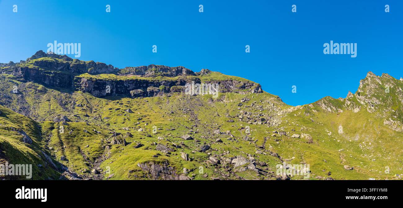 Creste verdi e robuste dei Carpazi sotto un cielo blu terso in Romania Foto Stock