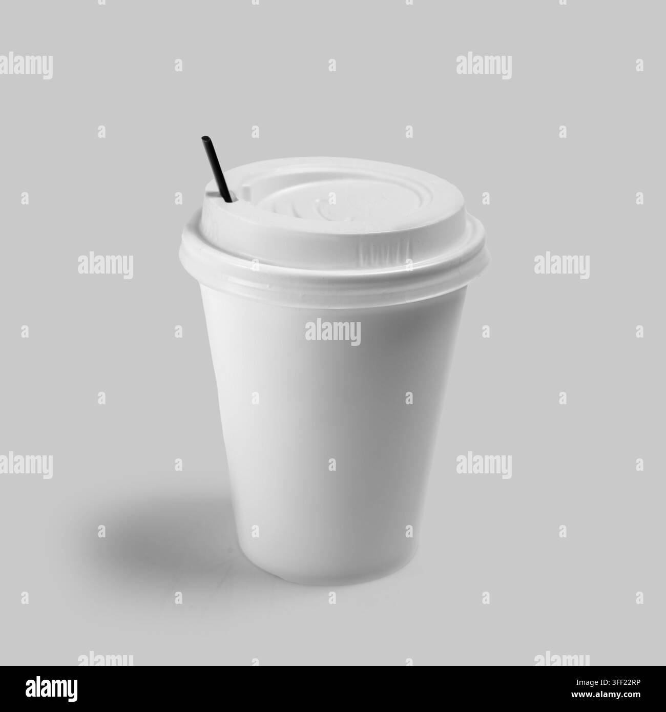 Tazza da caffè di carta bianca vuota con coperchio e cucchiaio nero su sfondo grigio chiaro. Modello di mockup ideale. Mockup o spazio per testo Foto Stock
