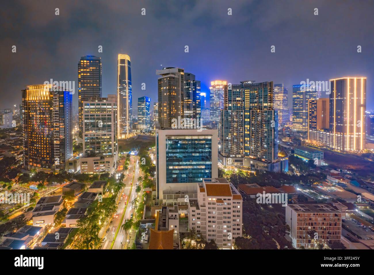 Splendida vista aerea dello skyline di Giakarta di notte, che mostra grattacieli moderni illuminati e strade urbane vivaci nel distretto degli affari. J Foto Stock