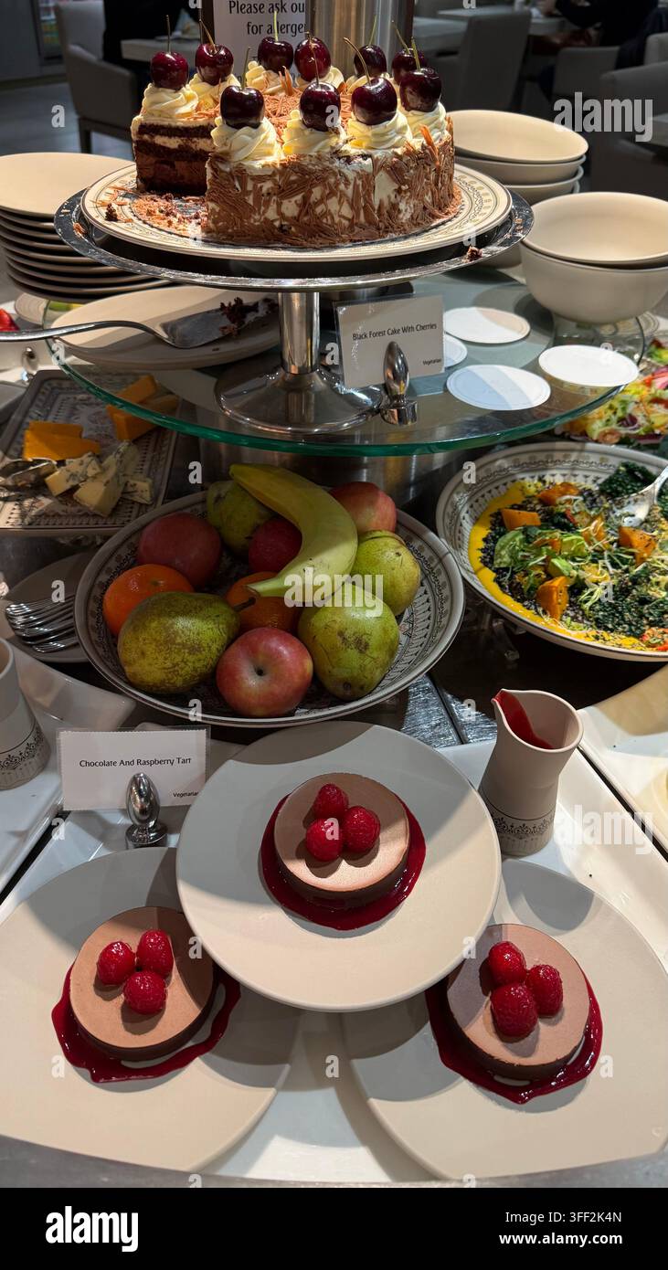 Una mostra e offerte di una vasta selezione di frutta fresca, torte e dessert in una lounge business degli Emirates per passeggeri di classe business e prima classe - Immagine stock catturata con smartphone