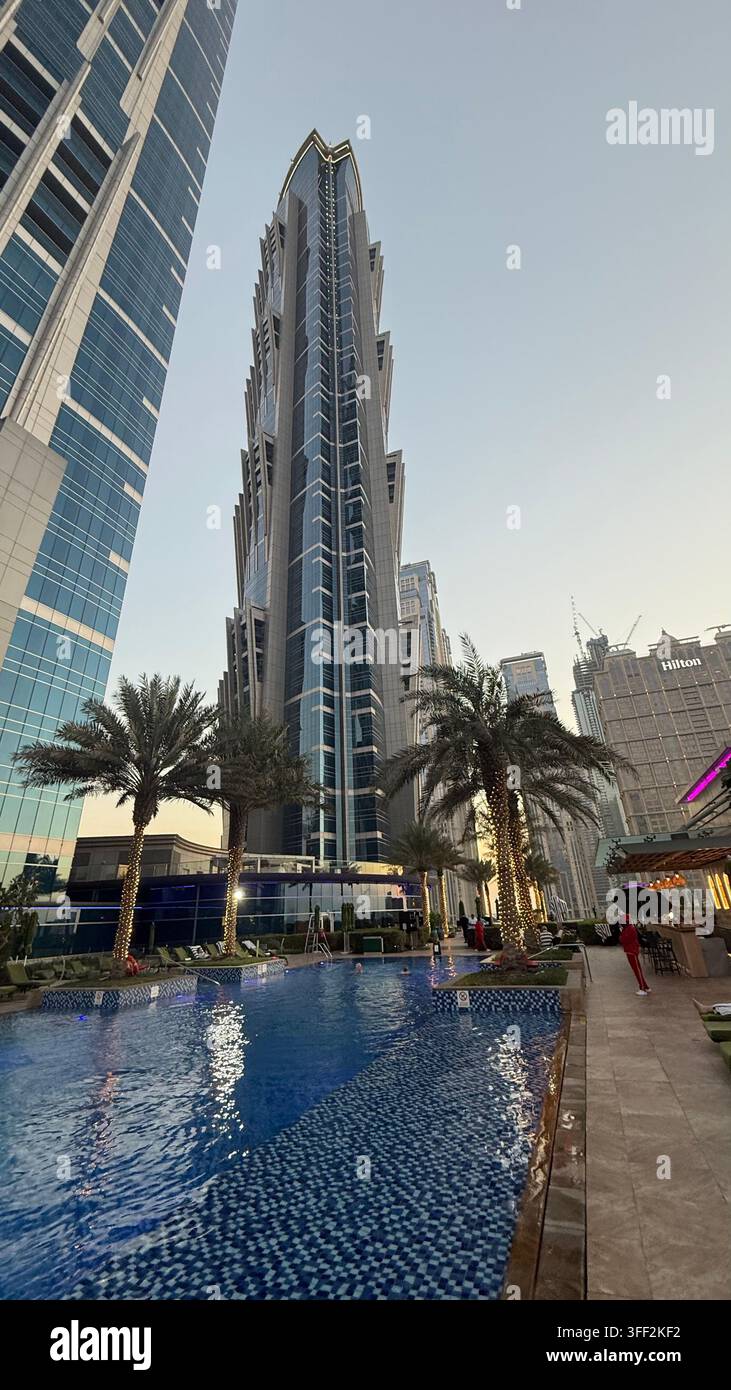 Ambientazione del primo pomeriggio sugli appartamenti e uffici moderni rialzati intorno al ponte della piscina all'aperto del JW Marriott Marquis Hotel Dubai - Immagine stock catturata con smartphone