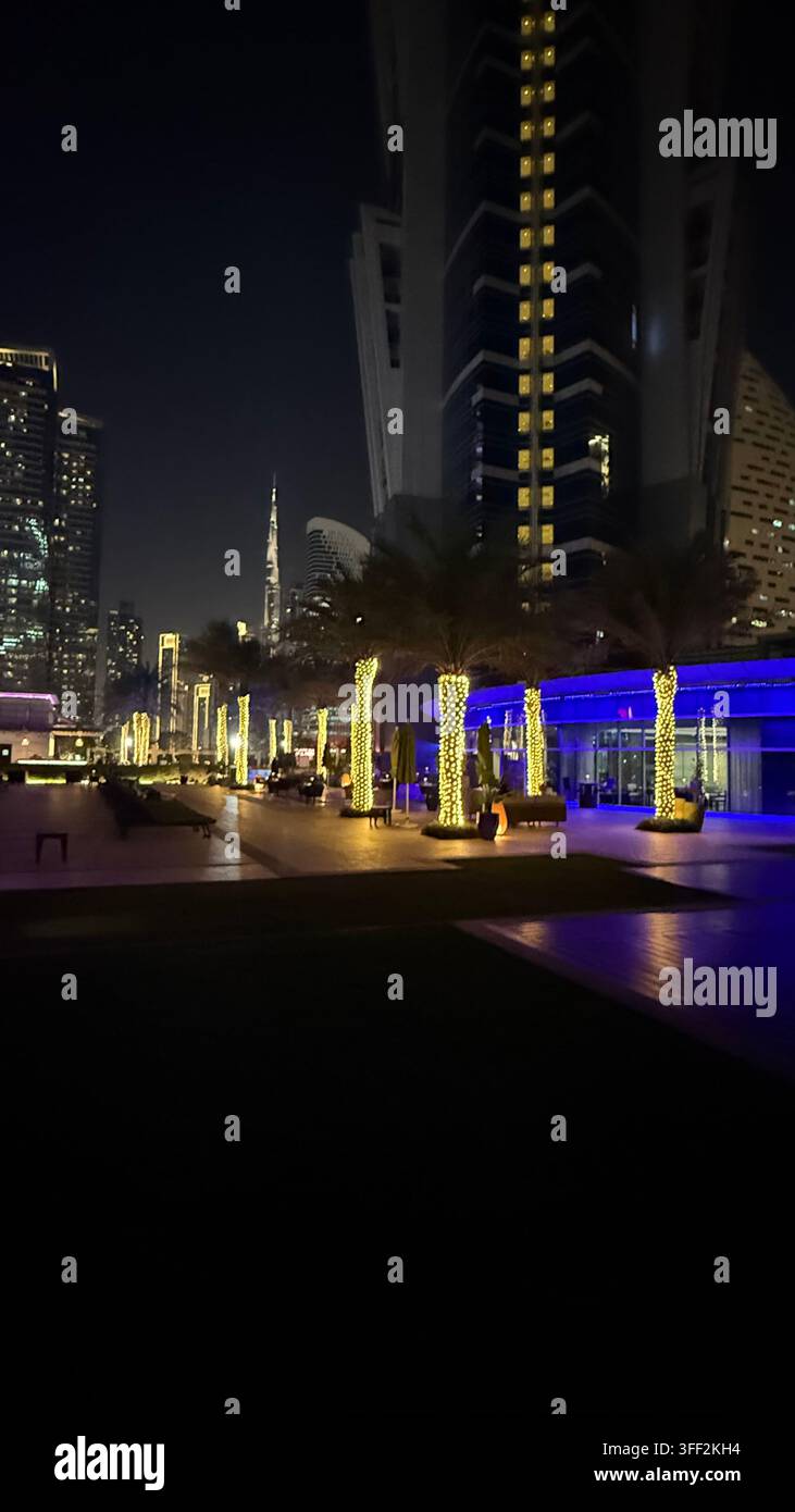 Ambientazione del primo pomeriggio sul Burj Khalifa alto, appartamenti e uffici moderni rialzati attorno al molo della piscina all'aperto illuminato al JW M - Immagine stock catturata con smartphone