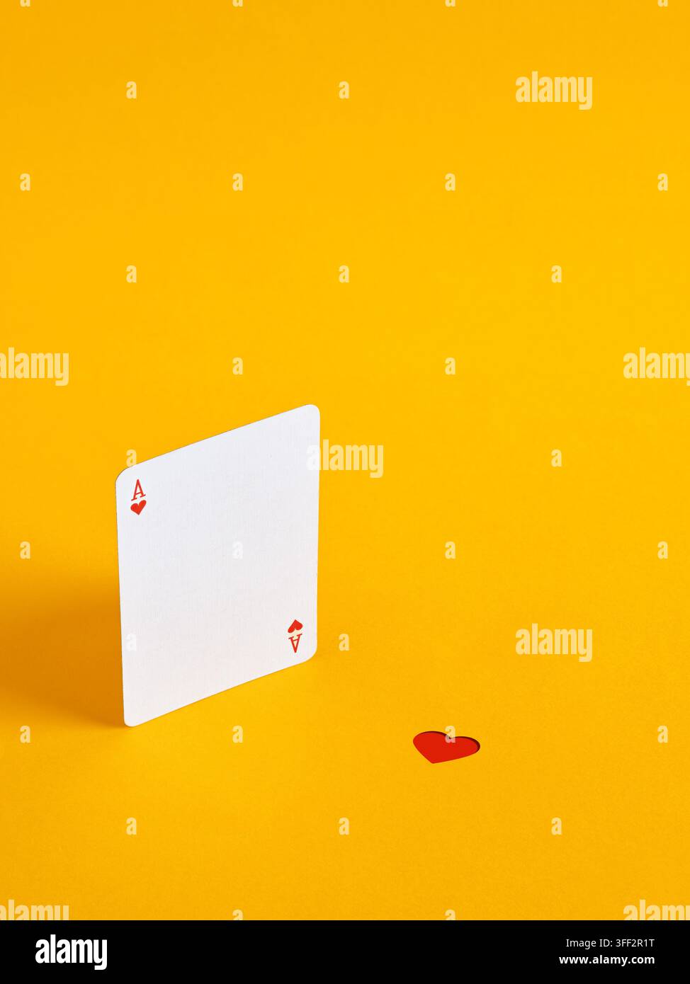 ACE di cuori che giocano a carte e un piccolo cuore rosso separato, che simboleggia l'amore perduto, una relazione interrotta e opportunità perse. Foto Stock