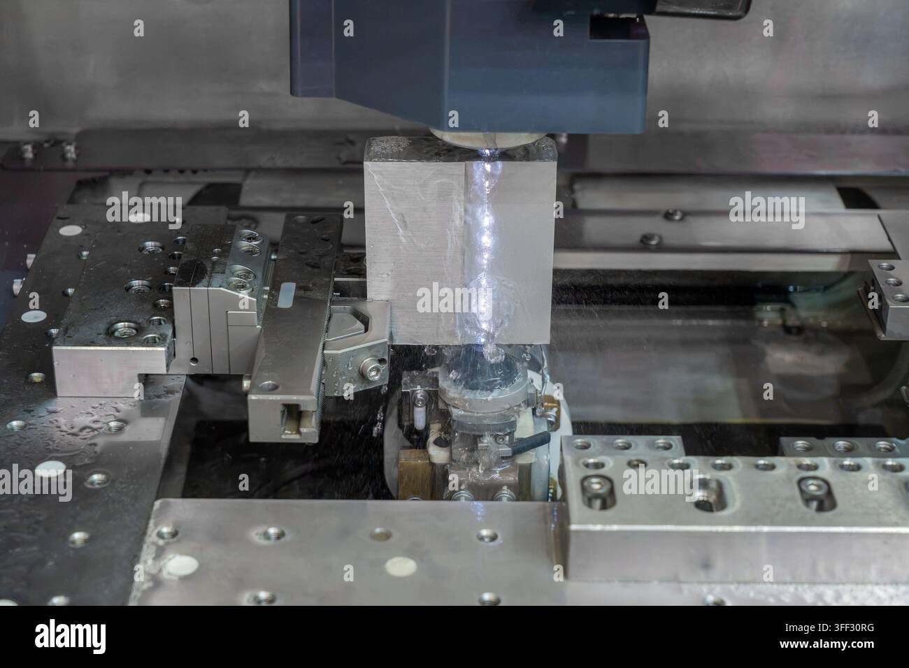 Elettrificazione a filo di una pieza metallica con filo di taglio di precisione e fluido dielettrico in un'officina industriale Foto Stock