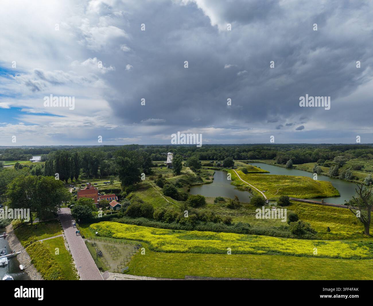 Fotografia aerea ampia e orizzontale ad angolazione alta con drone che cattura la città storica di Veere, Zelanda, Paesi Bassi. L'inquadratura si affaccia su erba verde Foto Stock