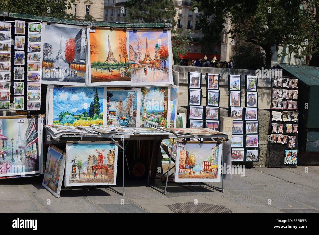 I librai parigini mostrano opere d'arte nelle strade piene di turisti e gente del posto. Foto Stock
