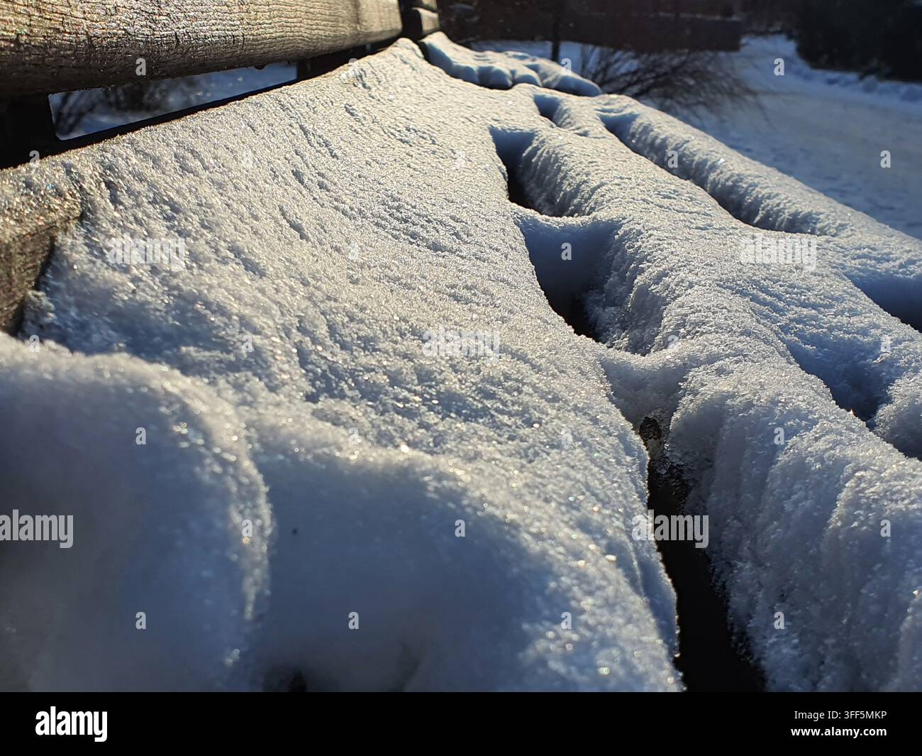 Fotografia macro in primo piano di materiale tessile o stoffa pesante completamente ricoperta da uno spesso strato di brina e neve. La superficie mostra creste profonde e Foto Stock