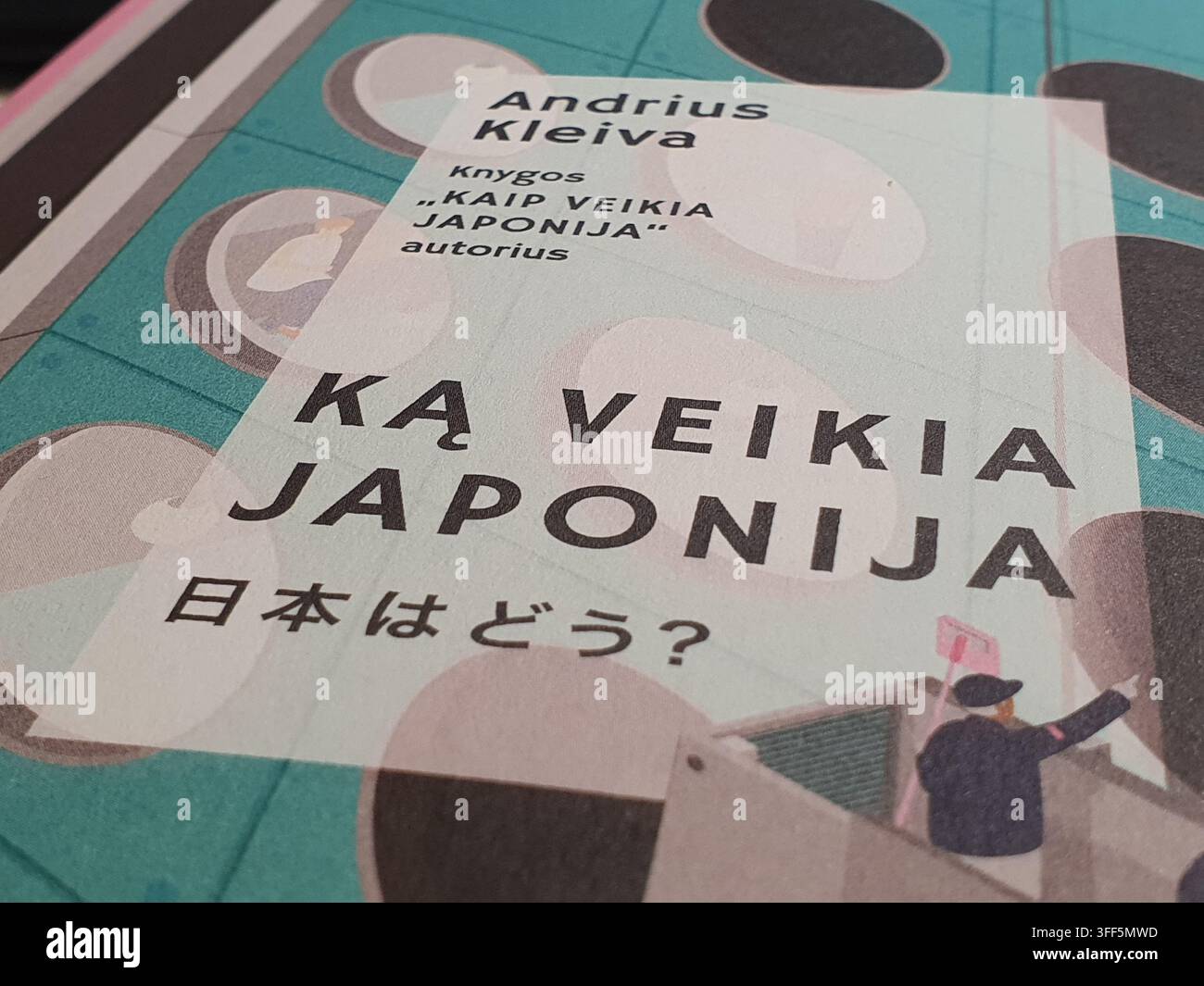 Fotografia in primo piano di una copertina di libro lituana o di un segnalibro promozionale per il libro "Ką veikia Japonija" (Cosa fa il Giappone?) dell'autore Andrius Foto Stock